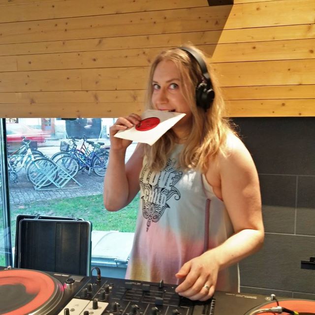 DJ Minna T levylautasten takana puremassa 7-tuuman vinyyliä.